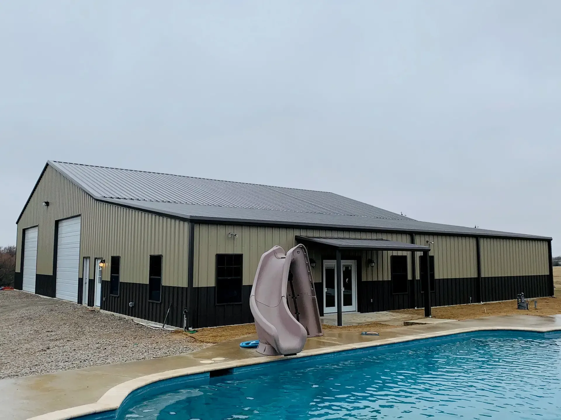 view of a barndominium with a slide into a pool