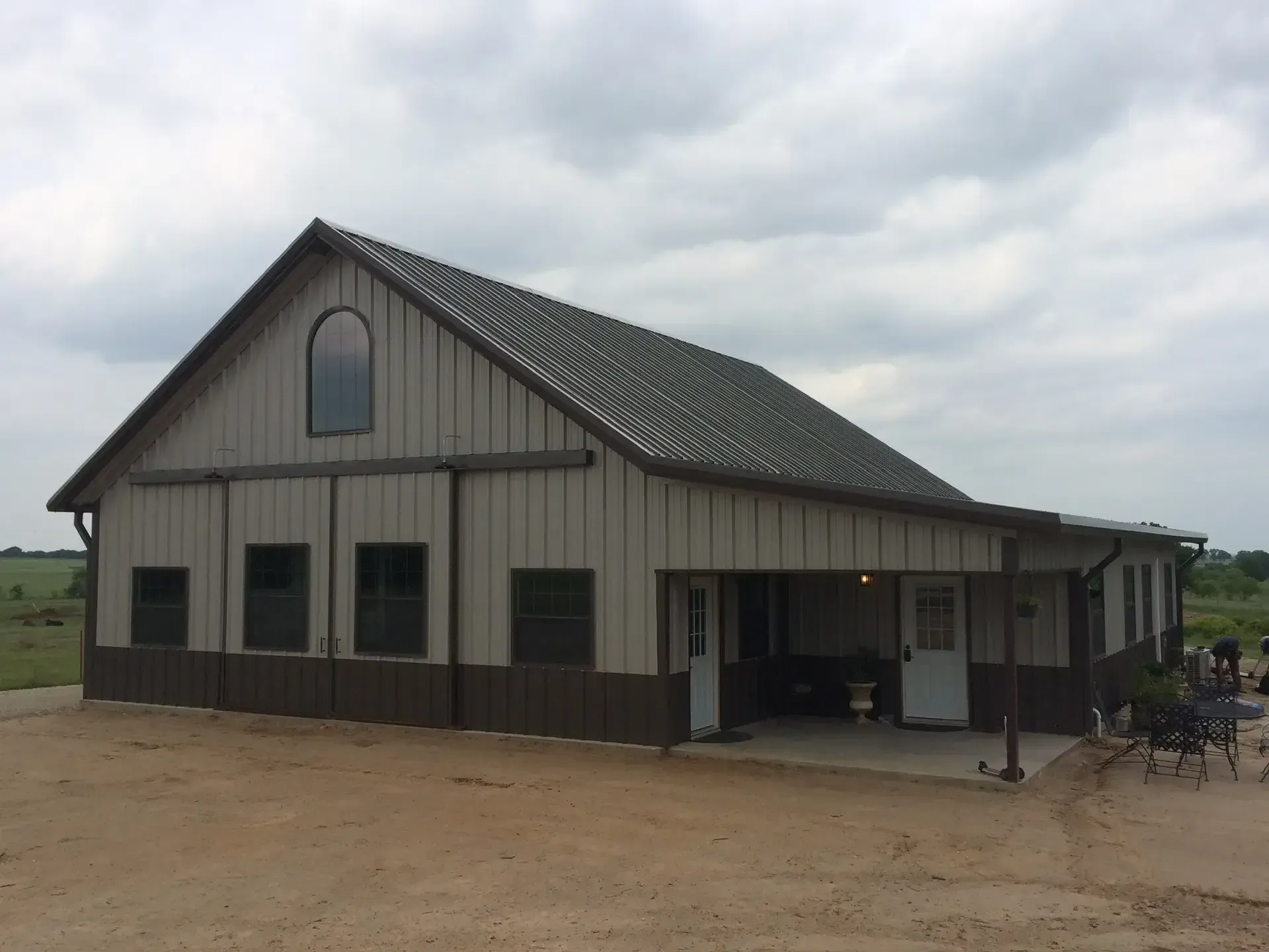 medium and dark tan barndominium with high pitch